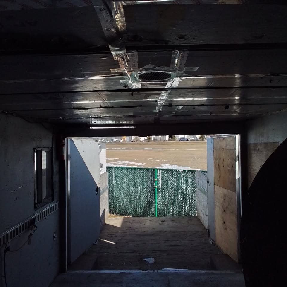 Interior view through the enclosed trailer doors with space for protected cargo, tools and job materials.